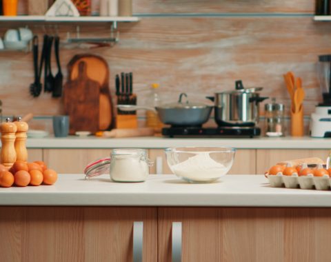 pastry-ingredients-homemade-cakes-bread-empty-kitchen-modern-dining-room-equipped-with-utensils-ready-cooking-with-wheat-flour-glass-bowl-fresh-eggs-table